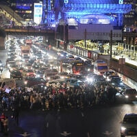 מפגינים, התובעים לשחרר את החטופים המוחזקים ברצועת עזה, חוסמים את התנועה דרומה בנתיבי איילון, 24 בינואר 2024 (צילום: AP Photo/Ohad Zwigenberg)