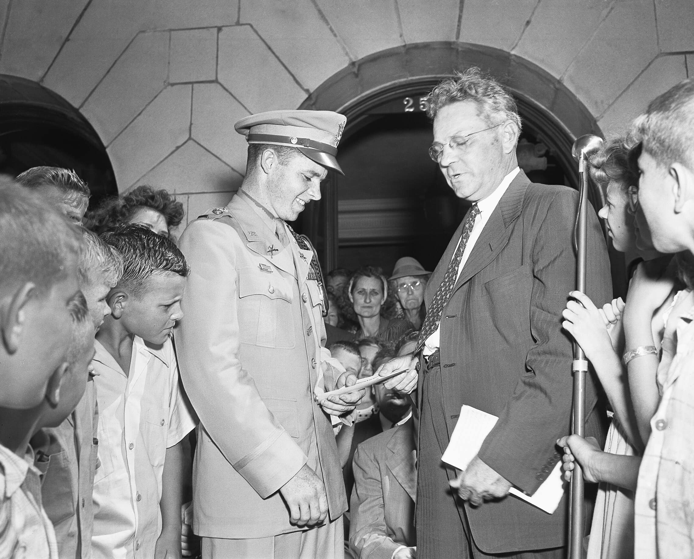אודי מרפי מקבל צ&#039;ק בסך אלף דולר ממפקד הלגיון האמריקאי בטקסס, 27 ביוני 1945 (צילום: AP Photo/Carl E. Linde)