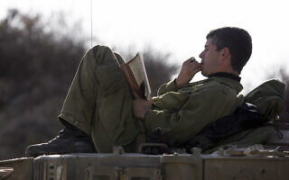אילוסטרציה: חייל קורא בשטח הכינוס לפני הכניסה לרצועת עזה (צילום: אדי ישראל/פלאש90)