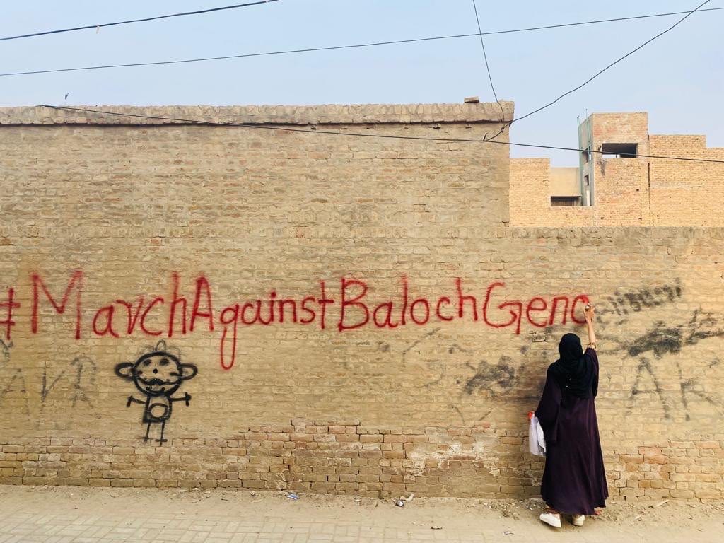 אישה מרססת גרפיטי בנושא הצעדה נגד רצח העם הבלוצ&#039;י, דצמבר 2023 (צילום: BYC)