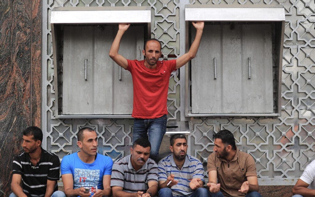 עובדים של הרשות הפלסטינית ממתינים מחוץ לסניף בנק בעיר עזה לקבל את משכורותיהם, יוני 2014 (צילום: Wissam Nassar/Flash90)