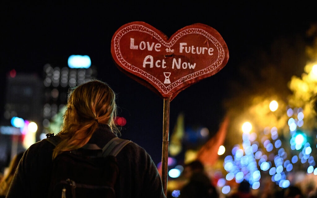מפגינה מחזיקה שלט עם הכיתוב, &quot;אהבו את העתיד, פעלו עכשיו&quot; בצעדת אקלים במדריד, 6 בדצמבר 2019 (צילום: OSCAR DEL POZO / AFP)
