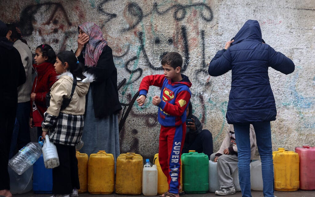 עקורים פלסטינים עומדים בתור ברפיח לקבל מים, 9 בפברואר 2024 (צילום: Mohammed ABED / AFP)