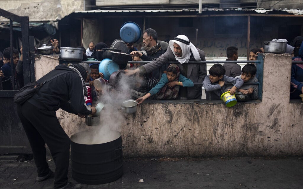 עקורים פלסטינים עומדים בתור לקבל אוכל ברפיח, 16 בפברואר 2024 (צילום: AP Photo/Fatima Shbair)