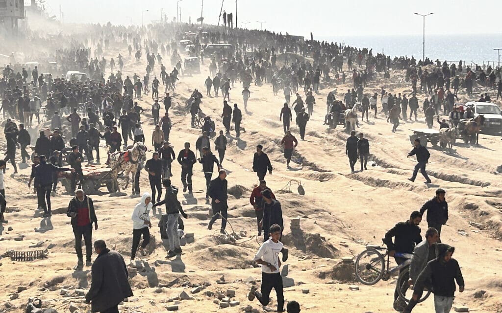 פלסטינים מחכים לסיוע הומניטרי על חוף הים בעיר עזה. 25 בפברואר 2024 (צילום: AP Photo/Mahmoud Essa)