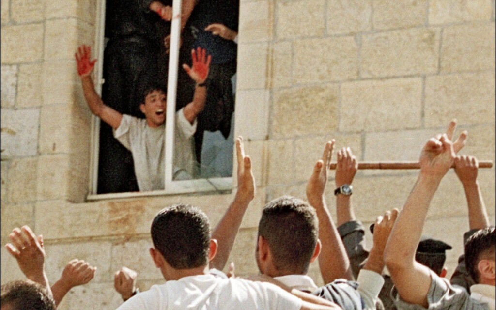 עבד אל-עזיז צאלחה בתחנת המשטרה ברמאללה מנופף להמון הפלסטיני בידיים מגואלות בדם, אחרי שהשליך את ואדים נורז&#039;יץ&#039; מהחלון, 12 באוקטובר 2000 (צילום: CHRIS GERALD / AFP)