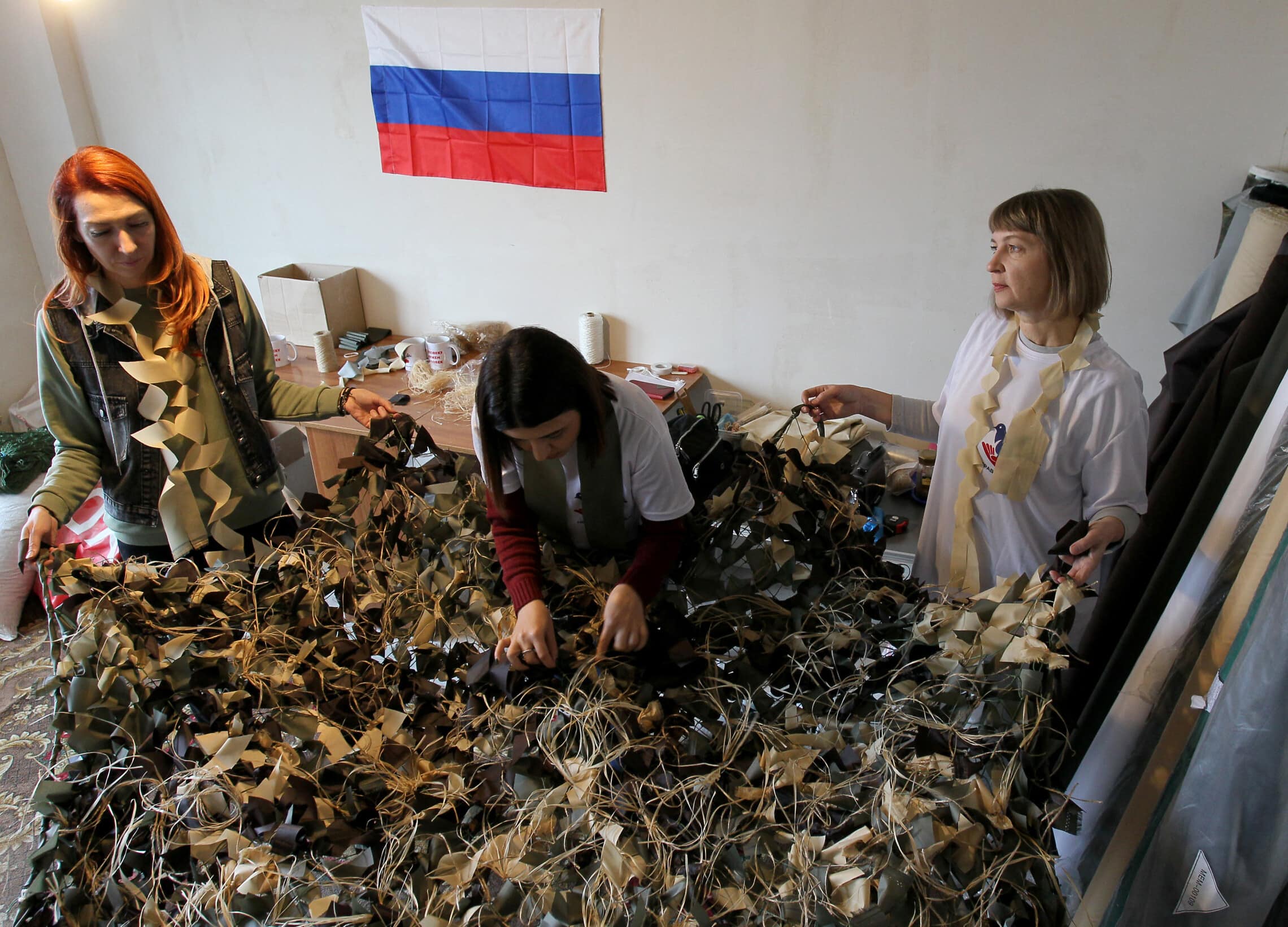 נשים רוסיות מתנדבות לייצר רשתות הסוואה לצבא הרוסי לצורך מלחמתו באוקראינה (צילום: STRINGER / AFP)