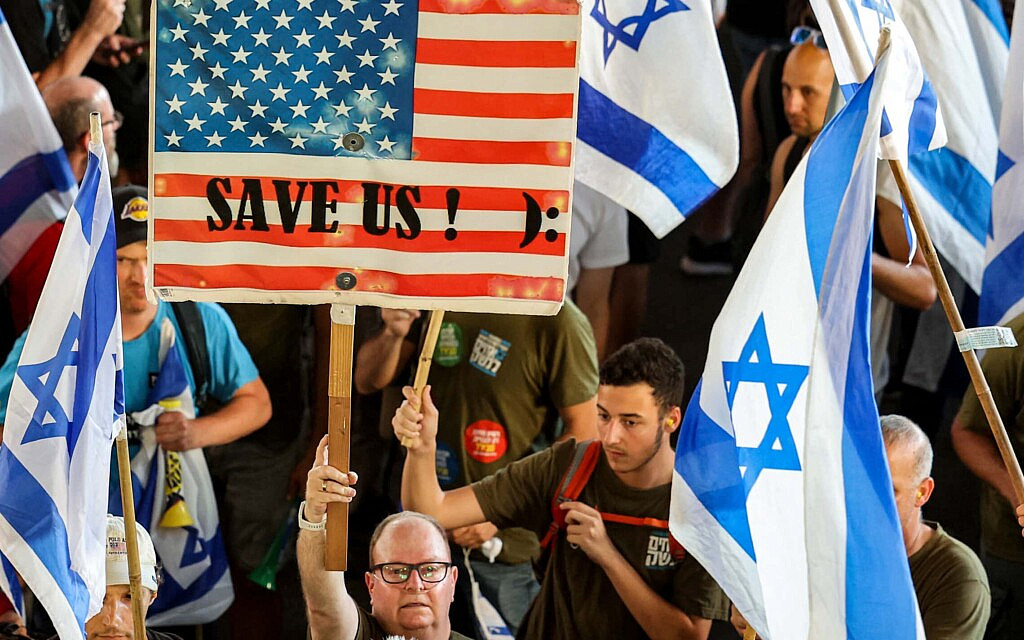 שלט הקורא לארצות הברית להציל את ישראל, בהפגנה בנתב"ג נגד ההפיכה המשטרית, 11 ביולי 2023 (צילום: JACK GUEZ / AFP)