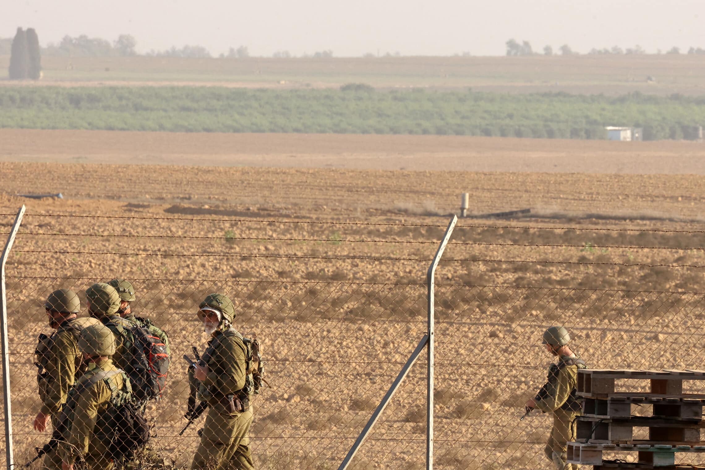 חיילים מפטרלים ליד הגדר המקיפה את קיבוץ ניר עוז, נובמבר 2023 (צילום: GIL COHEN-MAGEN / AFP)