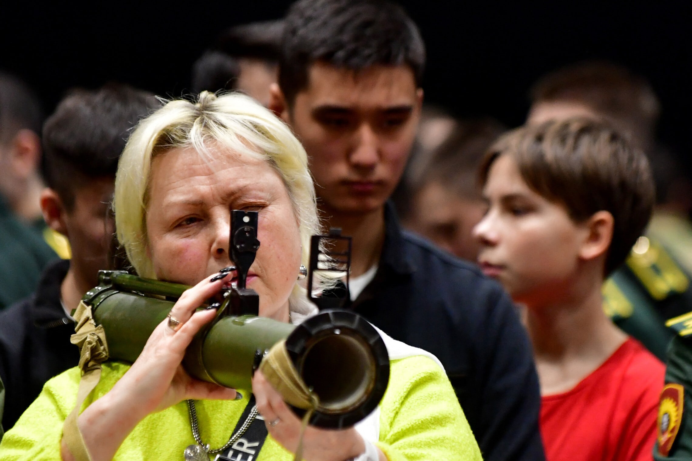 אישה משתמשת בנשק בפסטיבל צבאי-פטריוטי &quot;הרוסים משנים את העולם&quot; בסנט פטרסבורג ב-23 בפברואר 2024 (צילום: Olga MALTSEVA / AFP)