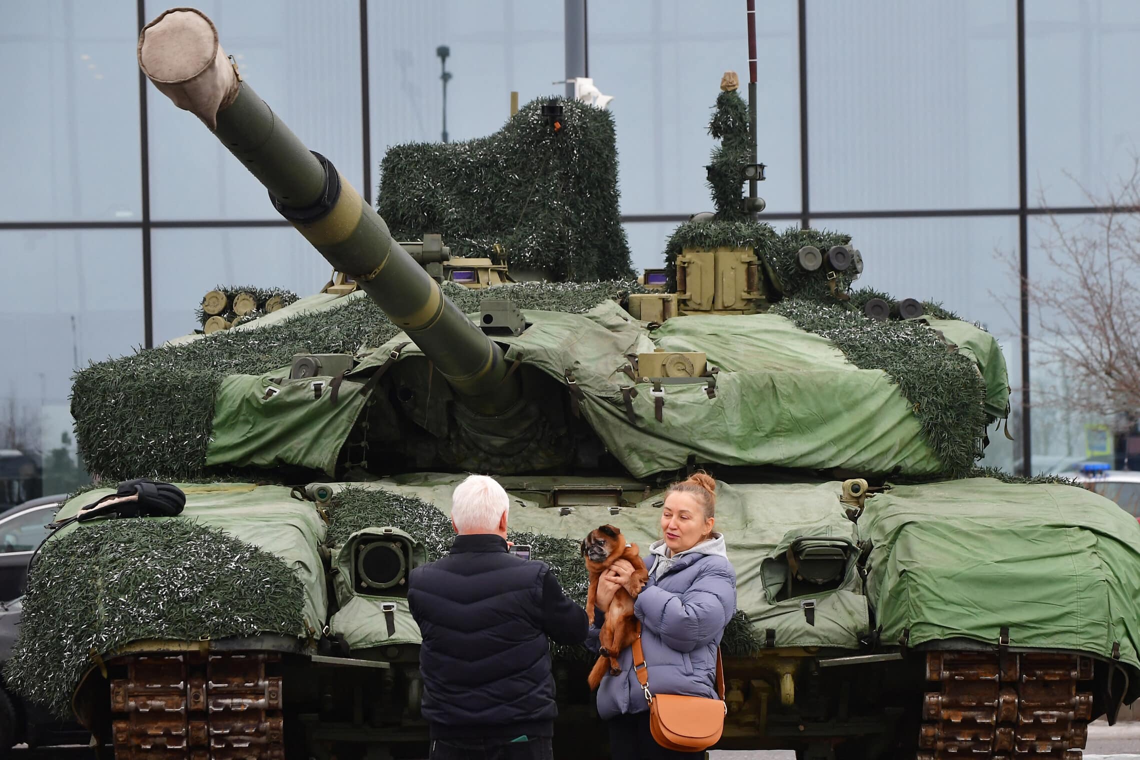 אישה מצטלמת עם כלב לצד טנק רוסי במהלך הפסטיבל הפטריוטי של הרוסים Change the World בסנט פטרסבורג ב-24 בפברואר 2024 (צילום: Olga MALTSEVA / AFP)
