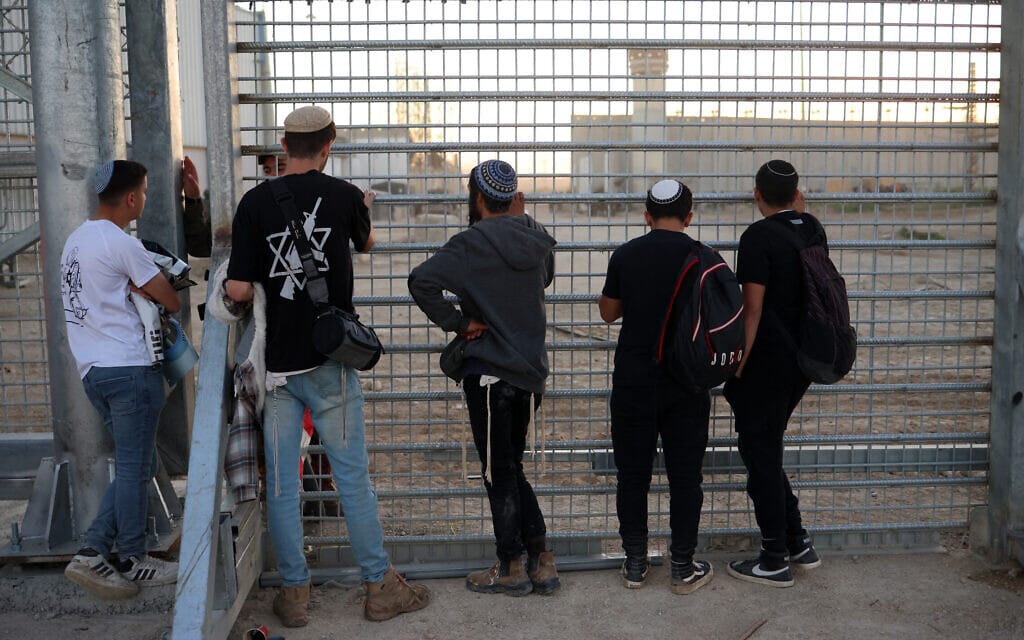 מתנחלים הקוראים לחידוש ההתיישבות בעזה צופים דרך הגדר המפרידה בין ישראל לרצועת עזה במעבר ארז, 29 בפברואר 2024 (צילום: Oren ZIV / AFP)