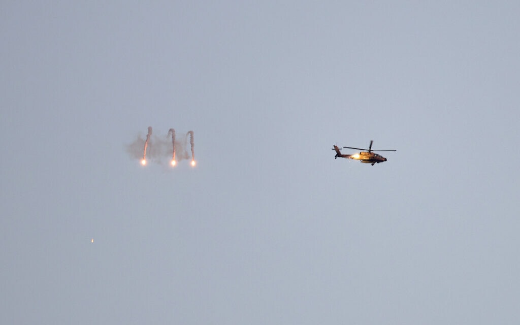 מסוק צה"ל יורה נורים מעל רצועת עזה. 4 במרץ 2024 (צילום: Menahem KAHANA / AFP)