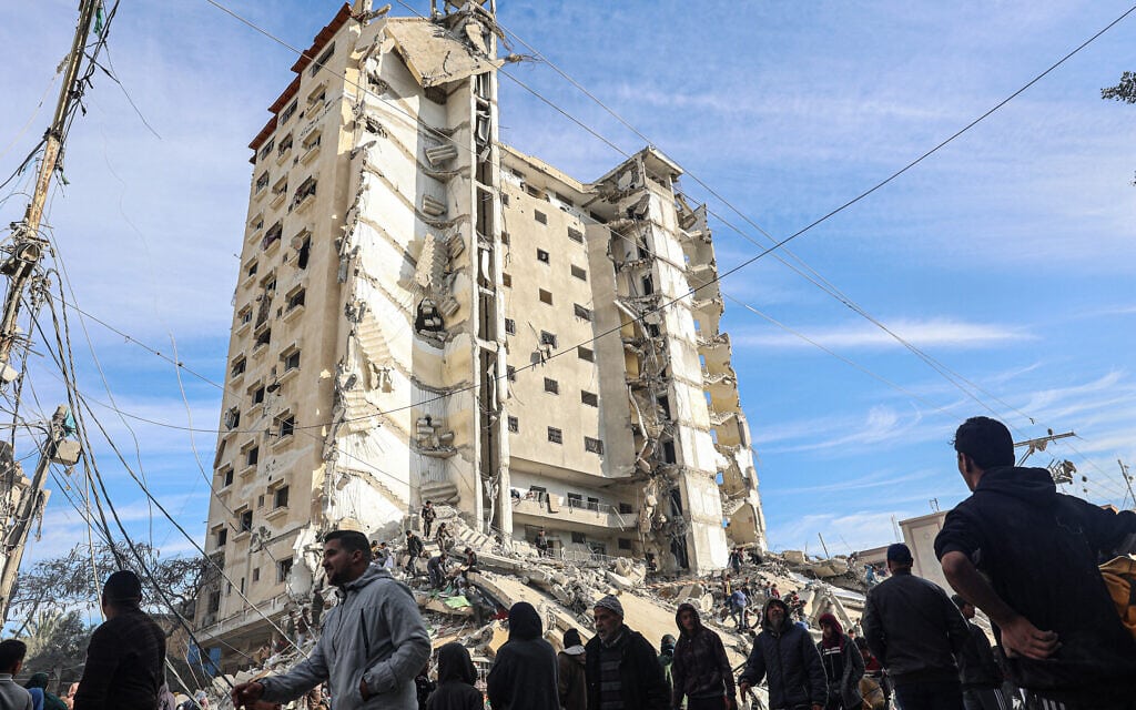 פלסטינים מתאספים מול בניין אל- מצרי שנפגע בתקיפה ישראלית ברפיח שבדרום רצועת עזה. 9 במרץ 2023 (צילום: SAID KATIB / AFP)