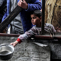 ילד פלסטיני ממתין לקבלת מזון ברפיח, 16 במרץ 2024
