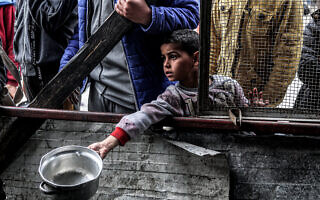 ילד פלסטיני ממתין לקבלת מזון ברפיח, 16 במרץ 2024 (צילום: SAID KHATIB / AFP)