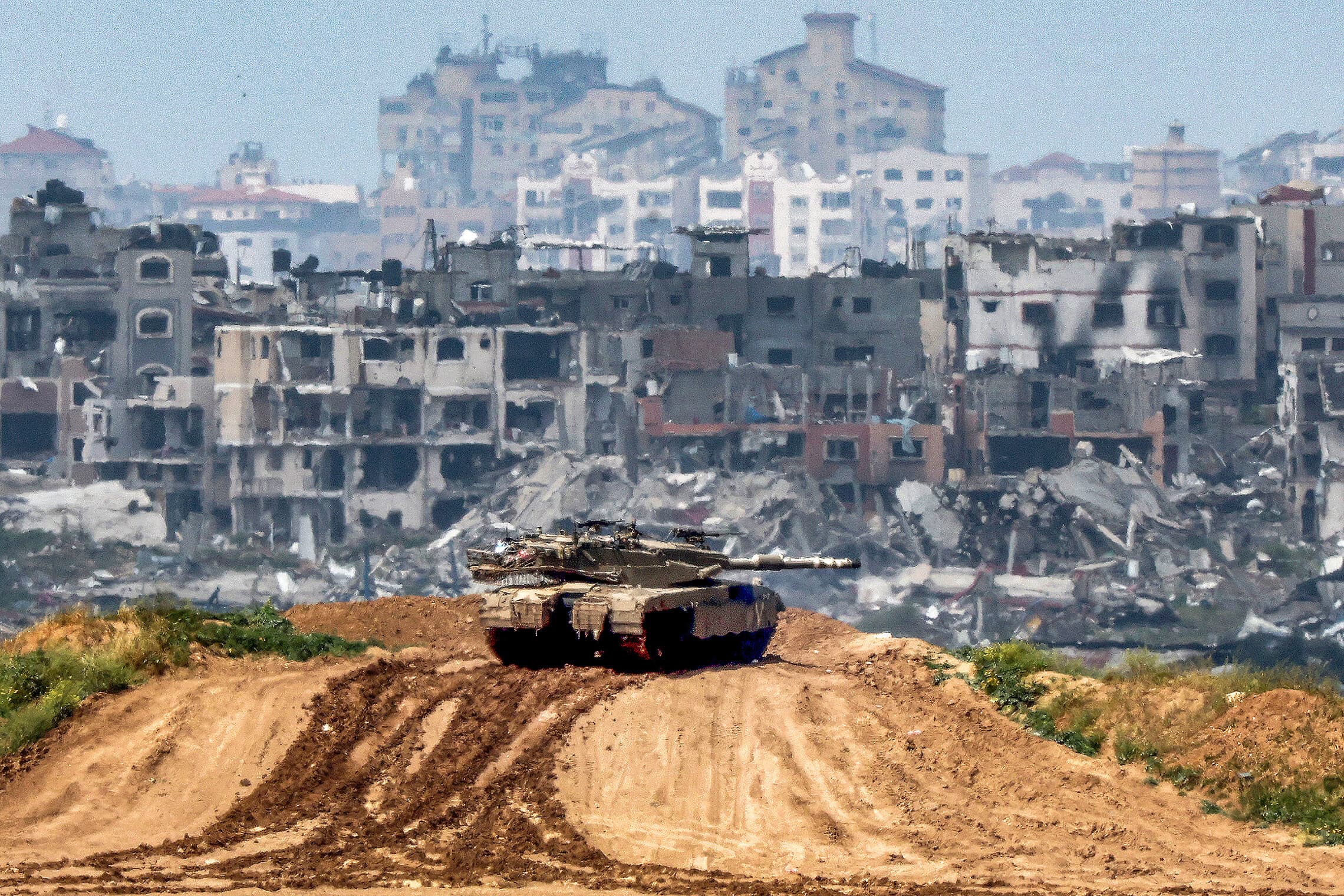 טנק ישראלי על רקע ההריסות בעזה, 19 במרץ 2024 (צילום: JACK GUEZ / AFP)