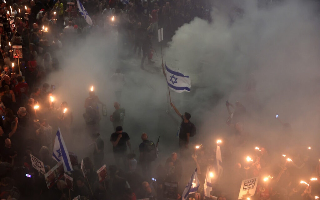 דגל ישראל עשן ולפידים בהפגנה נגד הממשלה בת"א. 30 במרץ 2024 (צילום: JACK GUEZ / AFP)