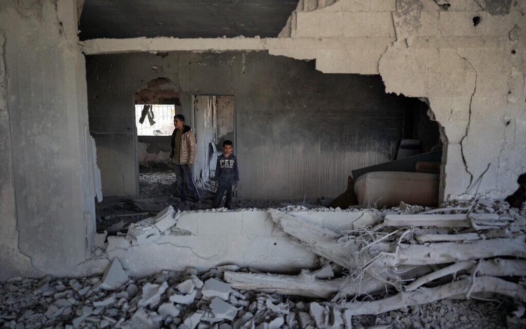 תושבי מחנה הפליטים אל-מע'אזי שבמרכז הרצועה בביתם, שנפגע בתקיפה ישראלית, 31 במרץ 2024 (צילום: AFP)