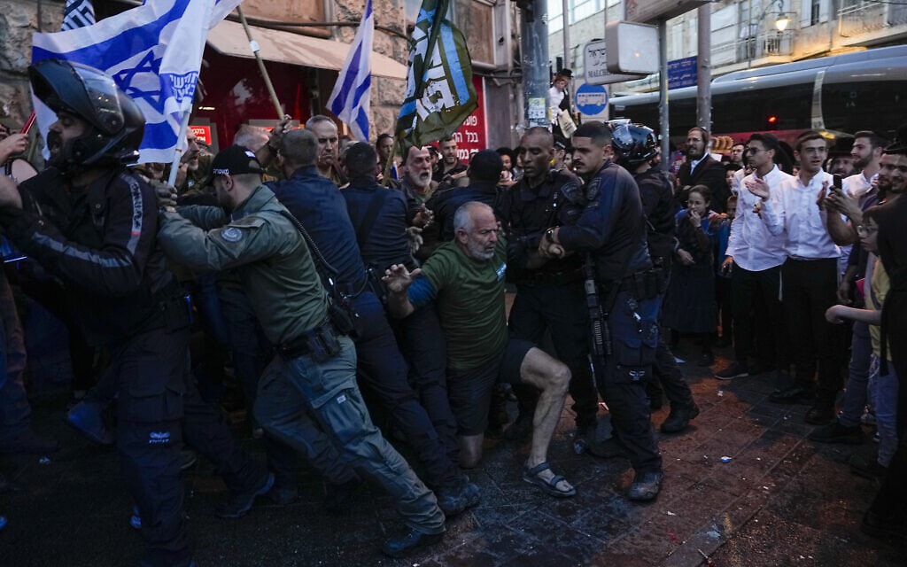 שוטרים בשכונת מאה שערים בירושלים מתעמתים עם מפגינים הקוראים לגיוס חרדים לצה"ל, 31 במרץ 2024 (צילום: AP Photo/Ohad Zwigenberg)