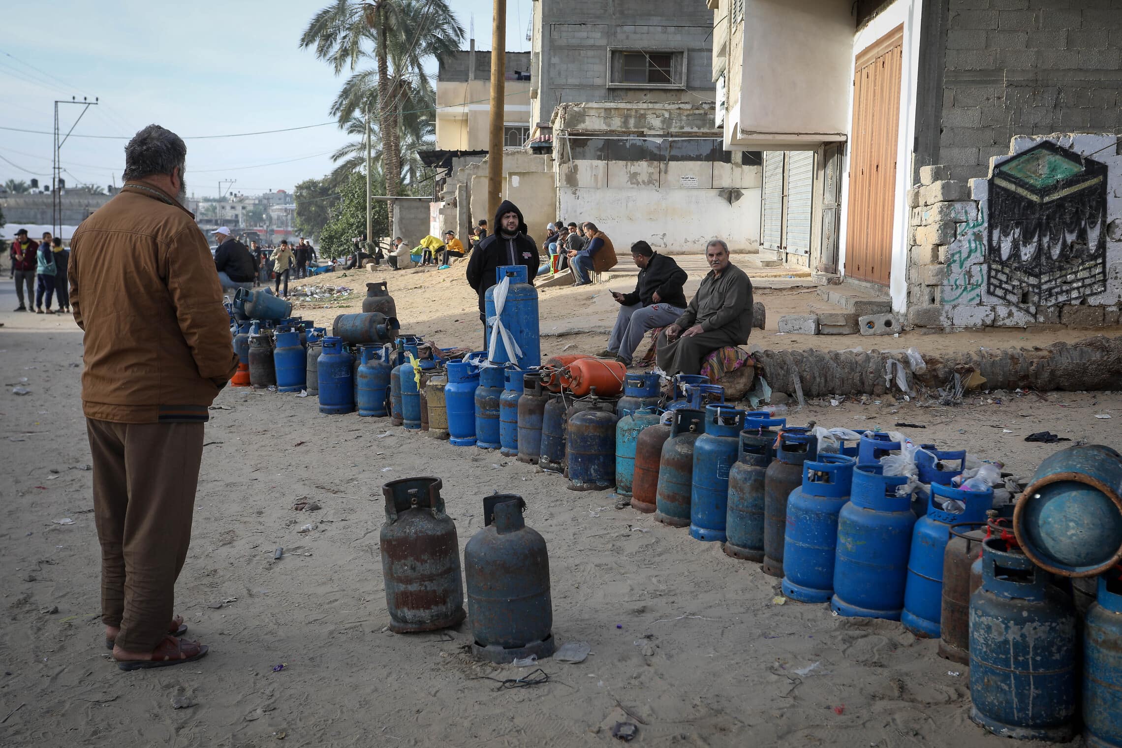 פלסטינים ממתינים למלא גז שנכנס מרפיח בדרום רצועת עזה. 25 בנובמבר 2023 (צילום: Abed Rahim Khatib/Flash90)
