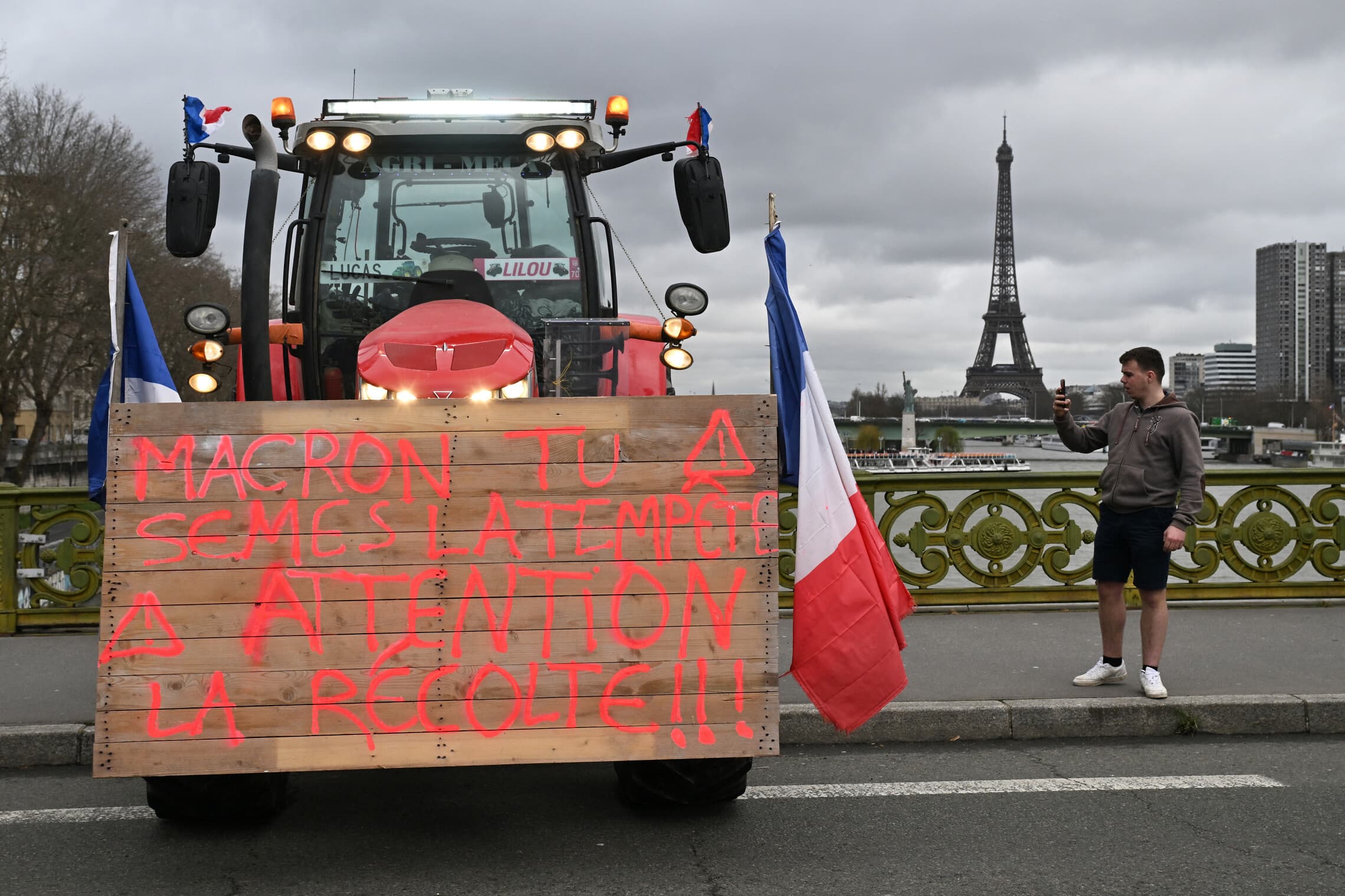טרקטור עם כתובת מחאה חונה עם מגדל אייפל ברקע במהלך הפגנת חקלאים בפריז ב-23 בפברואר, 2024 (צילום: Miguel MEDINA / AFP)
