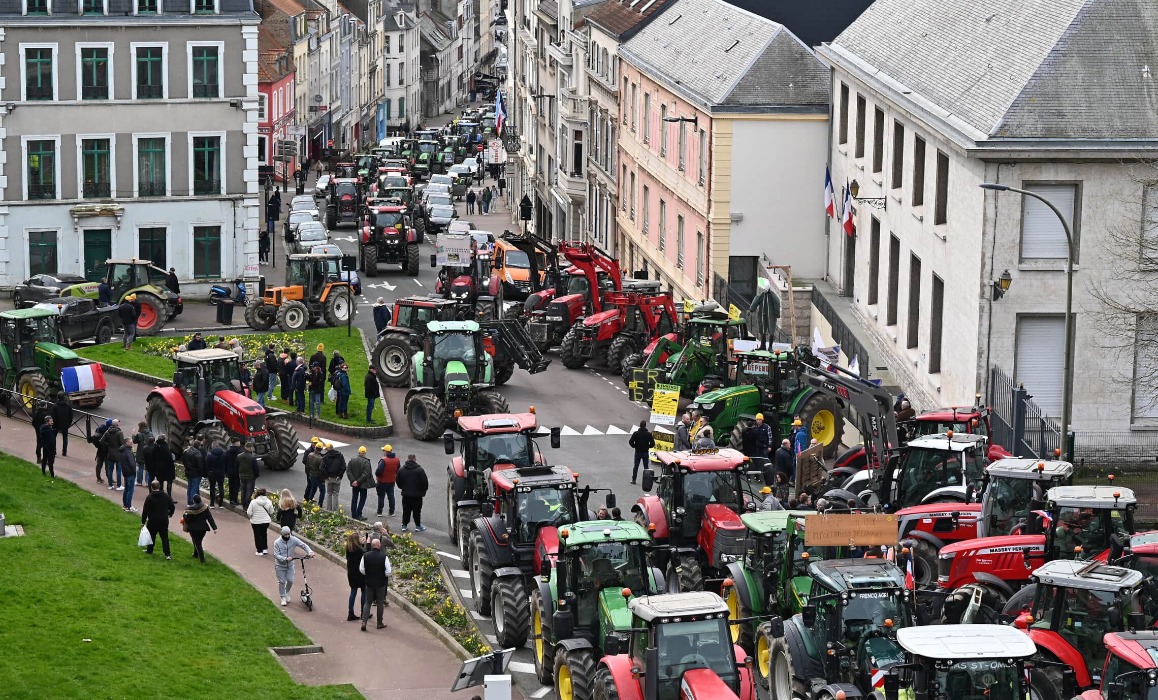 חקלאים צרפתים עומדים ליד טרקטורים במהלך מחאת חקלאים ב-9 במרץ 2024 (צילום: BERNARD BARRON / AFP)