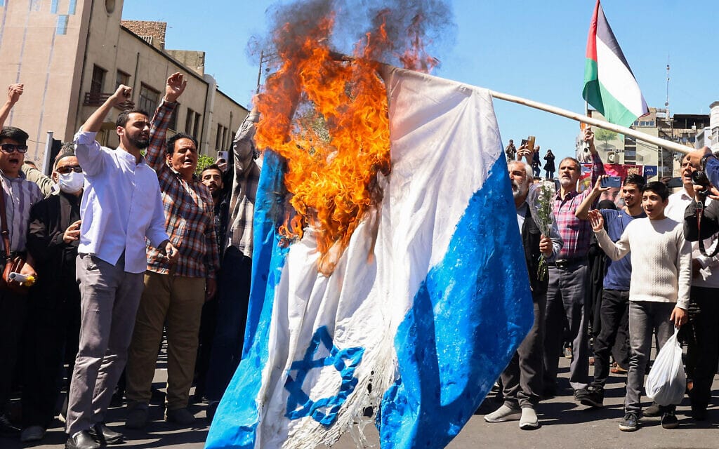 איראנים שורפים את דגל ישראל במהלך מצעד הלוויה של חסן מהדווי בטהרן, 5 באפריל 2024 (צילום: ATTA KENARE / AFP)