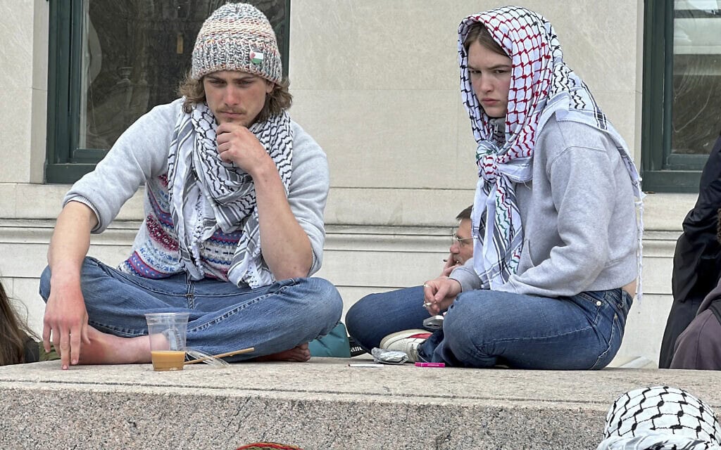 סטודנטים אמריקאים עוטים כאפייה כחלק מהמחאה הפרו-פלסטינית נגד ישראל בקמפוס של אוניברסיטת קולומביה בניו יורק, 24 באפריל 2024 (צילום: AP Photo/Ted Shaffrey)