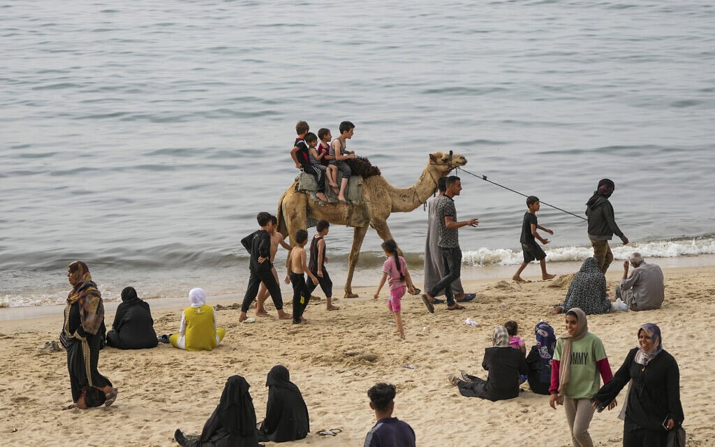 פלסטינים מעבירים את גל החום בחוף הים בדיר אל בלח, רצועת עזה, 25 באפריל 2024 (צילום: AP Photo/Abdel Kareem Hana)