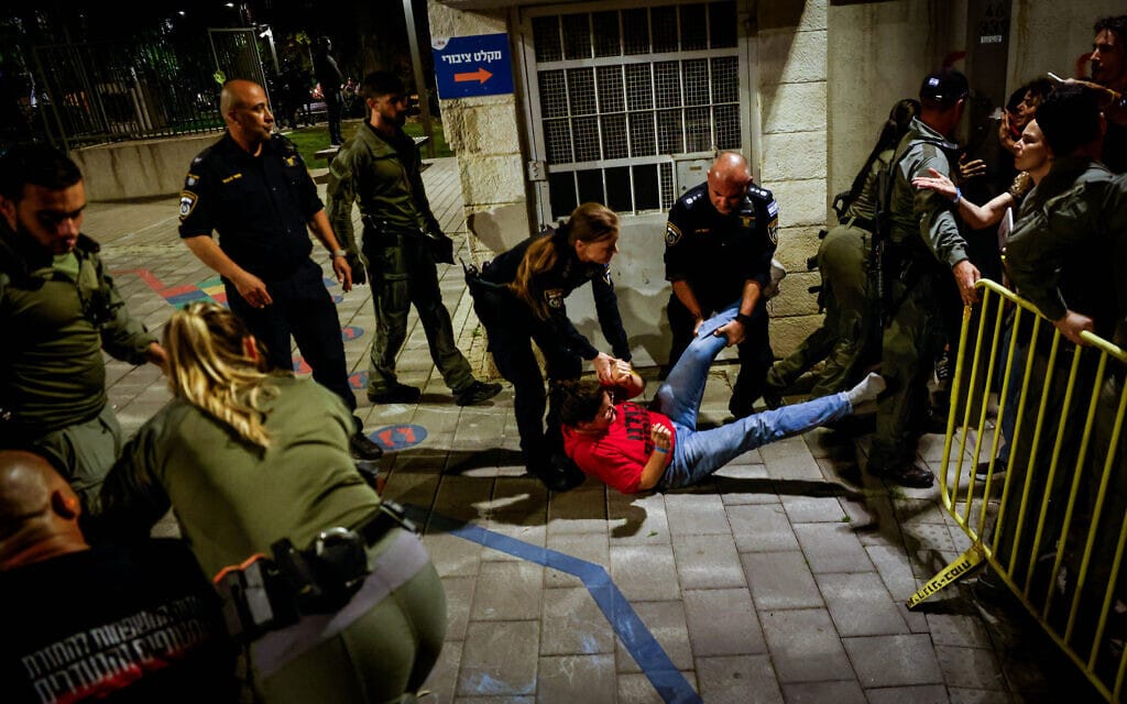 שוטרים גוררים את איילה מצגר, כלתו של יורם מצגר שנחטף לעזה, בהפגנה מול בית ראש הממשלה בנימין נתניהו בירושלים. 2 באפריל 2024 (צילום: חיים גולדברג/פלאש90)