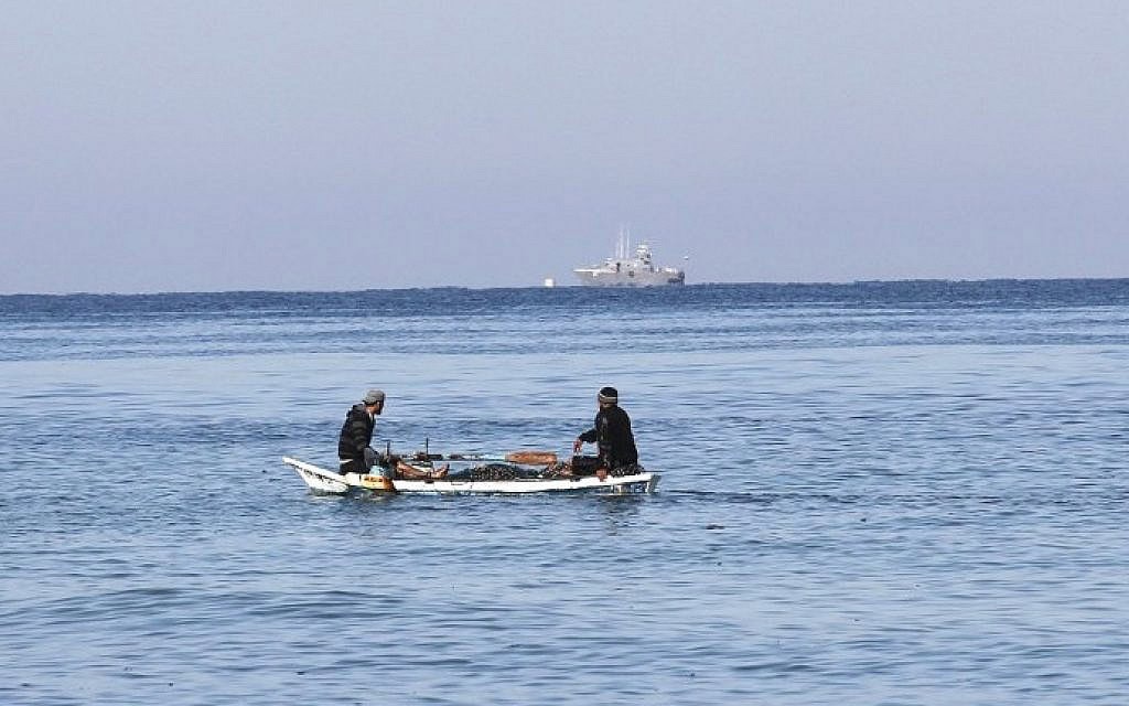 דייגים פלסטינים יושבים בסירה מול חוף העיר רפיח שבדרום רצועת עזה, כשבמרחק נראית סירה של משטרת ישראל, 26 במרץ 2014 (צילום: AFP/Said Khatib)