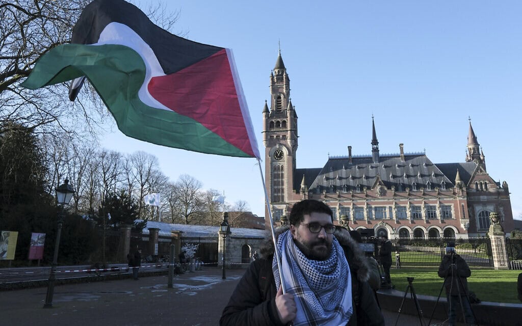 מפגין פרו פלסטיני מחוץ לארמון השלום בהאג, מקום מושבו של בית הדין לצדק. 26 בינואר 2024 (צילום: AP Photo/Patrick Post)