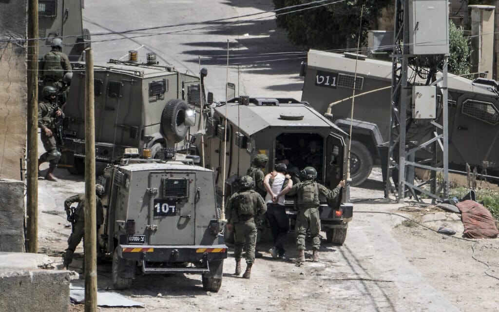 אנשי כוחות הביטחון עוצרים פלסטיני בדיר אל-ע'וסון, שבקרבת טולכרם, 4 במאי 2024 (צילום: AP Photo/Majdi Mohammed)