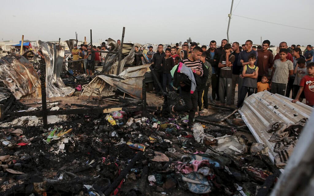 פלסטינים בוחנים אתר ברפיח שנפגע בתקיפה ישראלית, 27 במאי 2024 (צילום: AP Photo/Jehad Alshrafi)