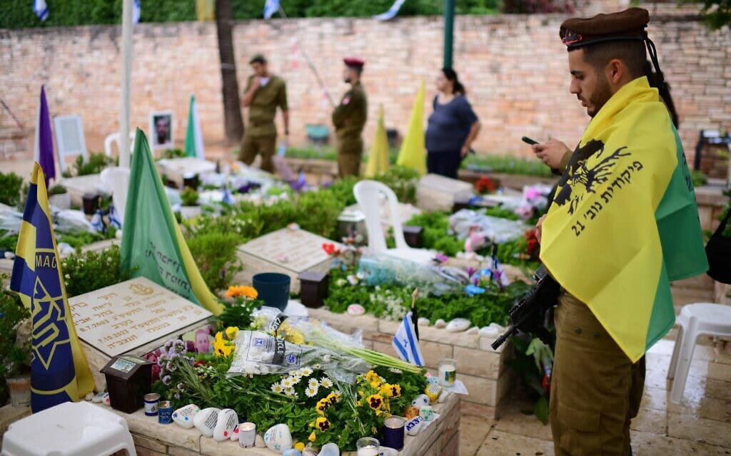 חייל עטוךך בדגל גולני מול קברו של רועי ברק שנפל ב-7.10. 13 במאי 2024 (צילום: תומר נויברג/פלאש90)