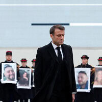 נשיא צרפת עמנואל מקרון עובר על פני משמרות הרפובליקה המחזיקים תמונות של אזרחי צרפת שנרצחו במתקפת חמאס בשבעה באוקטובר, 7 בפברואר 2024