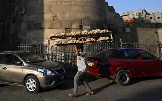 אדם מוכר לחם טרי בקהיר, 28 במאי 2024 (צילום: Khaled DESOUKI / AFP)