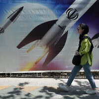 עוברת אורח בצפון טהרן חולפת על פני איור טילים איראניים, 19 באפריל 2024 (צילום: AP Photo/Vahid Salemi)