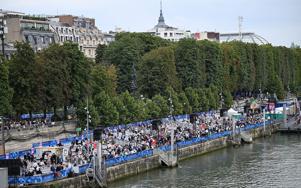 אנשים צופים בטקס פתיחת אולימפיאדת פריז על נהר הסיין, 26 ביולי 2024 (צילום: Hu Huhu / POOL / AFP)