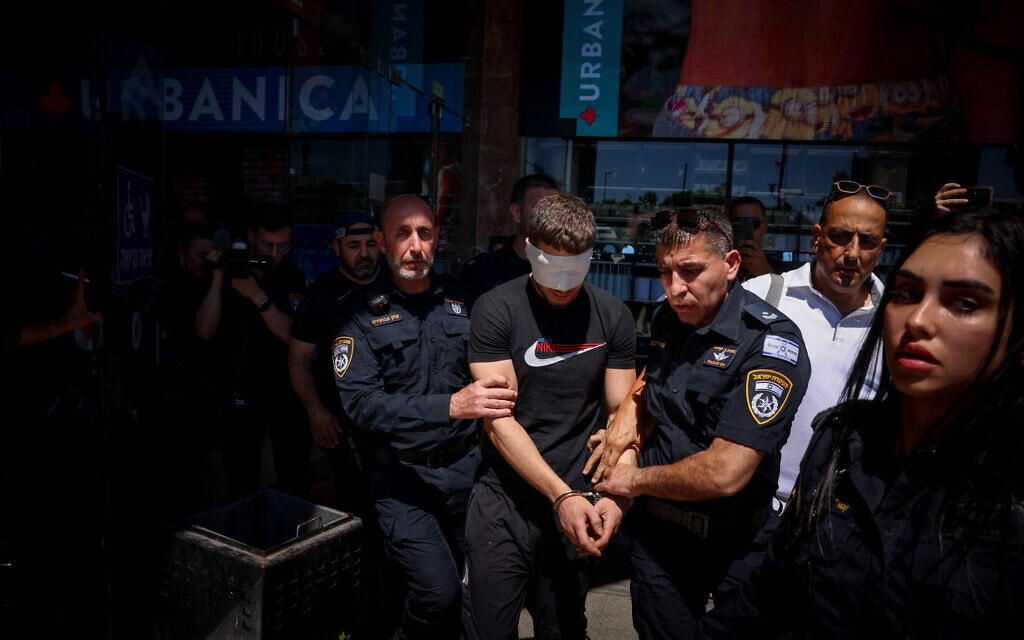 שוטרים עוצרים את אחד מקרוביו של המחבל שביצע את פיגוע הדקירה בכרמיאל, 3 ביולי 2024 (צילום: דוד כהן/פלאש90)