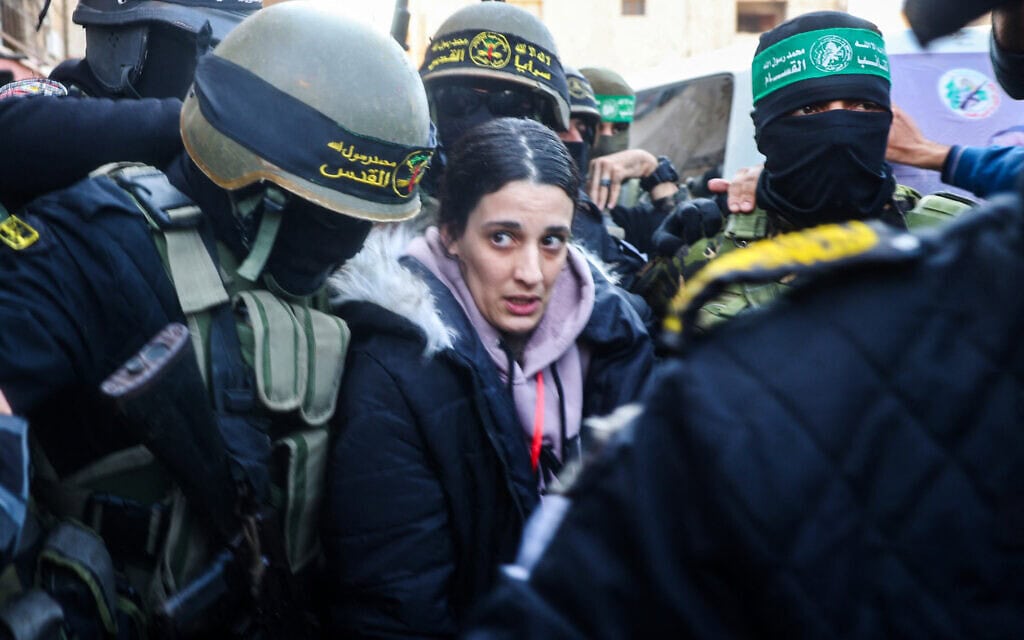 ארבל יהוד, מוקפת במחבלי הג'יהאד האסלאמי והמון עזתי, מועברת לידי הצלב האדום ליד ביתו של יחיא סנאוור בחאן יונס, 30 בינואר 2025 (צילום: Eyad BABA / AFP) ארבל יהוד, מוקפת במחבלי הג'יהאד האסלאמי והמון עזתי, מועברת לידי הצלב האדום ליד ביתו של יחיא סנאוור בחאן יונס, 30 בינואר 2025 (צילום: Eyad BABA / AFP)
