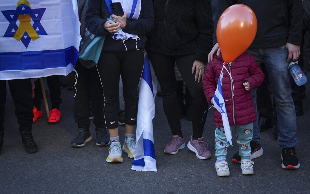 ילד עם בלון כתום במסע הלוויה של שירי ביבס ושני ילדיה, אריאל וכפיר, בראשון לציון. 26 בפברואר 2025 (צילום: AP Photo/Ariel Schalit) ילד עם בלון כתום במסע הלוויה של שירי ביבס ושני ילדיה, אריאל וכפיר, בראשון לציון. 26 בפברואר 2025 (צילום: AP Photo/Ariel Schalit)
