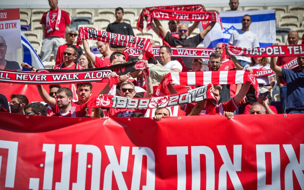 אוהדי הפועל ת"א מחזיקים דגלים בטקס לזכרו של צחי עידן בבלומפילד ב-28 בפברואר 2025 (צילום: אבשלום ששוני/פלאש90) אוהדי הפועל ת"א מחזיקים דגלים בטקס לזכרו של צחי עידן בבלומפילד ב-28 בפברואר 2025 (צילום: אבשלום ששוני/פלאש90)