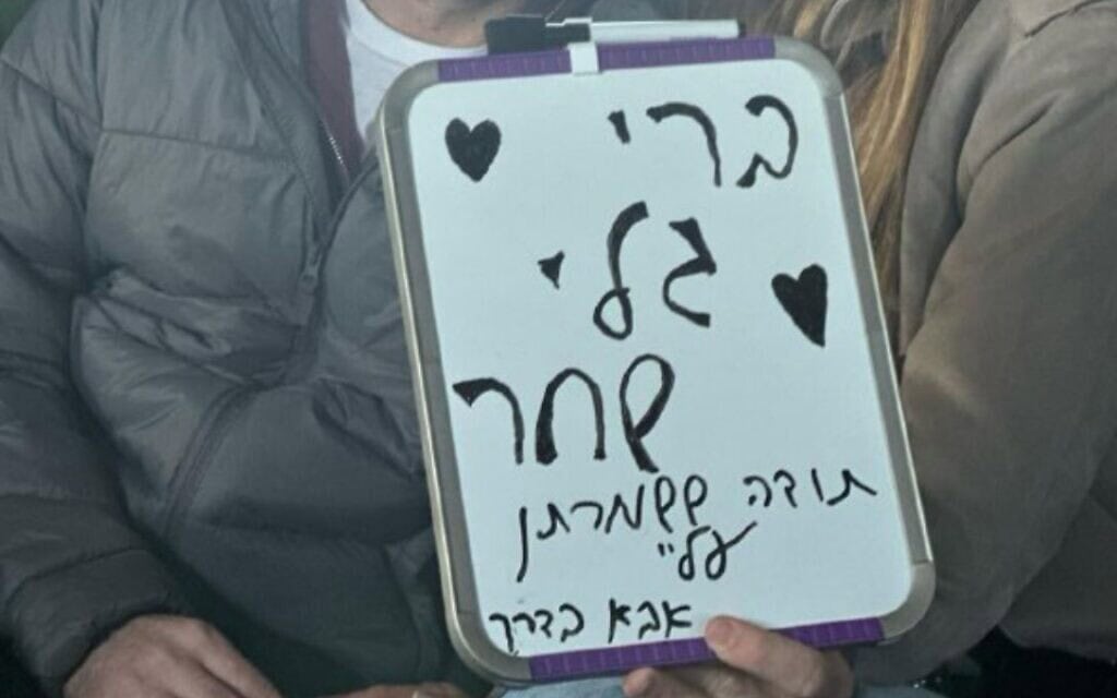 שורד השבי שגיא דקל חן במסוק כשהוא מחזיק בשלט ועליו מסר לבנותיו, 15 בפברואר 2025 (צילום: באדיבות המשפחה) שורד השבי שגיא דקל חן במסוק כשהוא מחזיק בשלט ועליו מסר לבנותיו, 15 בפברואר 2025 (צילום: באדיבות המשפחה)