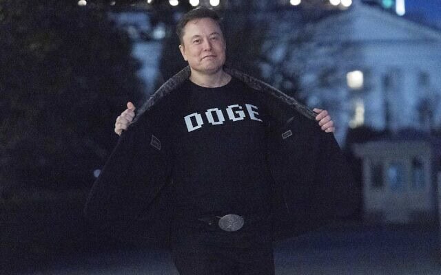 אילון מאסק מציג לעיתונאים חולצה עם הכיתוב "DOGE" במדשאה הדרומית של הבית הלבן בוושינגטון, 9 במרץ 2025 (צילום: AP Photo/Jose Luis Magana) אילון מאסק מציג לעיתונאים חולצה עם הכיתוב "DOGE" במדשאה הדרומית של הבית הלבן בוושינגטון, 9 במרץ 2025 (צילום: AP Photo/Jose Luis Magana)