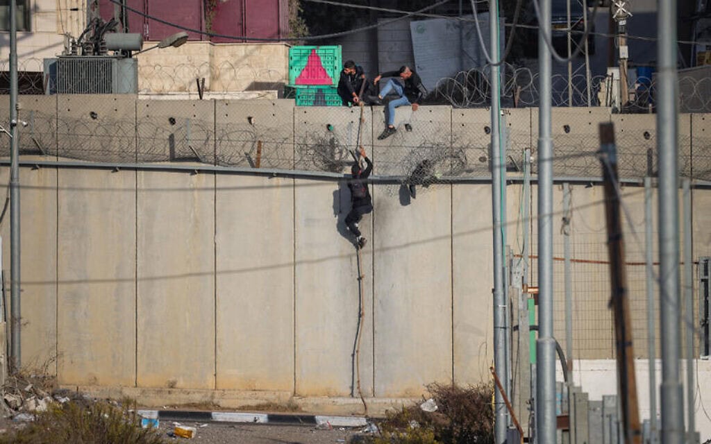 פלסטינים קופצים מעל גדר ההפרדה במזרח ירושלים. 28 באוקטובר 2024 (צילום: ג'מאל עוואד/פלאש90) פלסטינים קופצים מעל גדר ההפרדה במזרח ירושלים. 28 באוקטובר 2024 (צילום: ג'מאל עוואד/פלאש90)