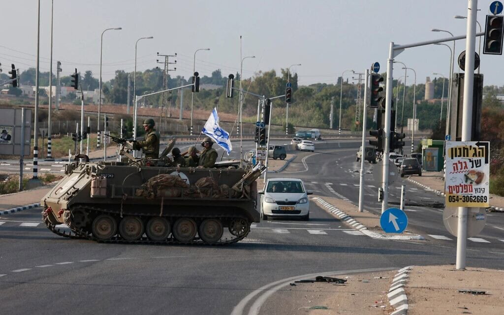 כוחות צה"ל חוצים כביש ראשי בנגמ"ש בצומת שער הנגב, בסמוך לשדרות, 8 באוקטובר 2023 (צילום: Menahem KAHANA / AFP) כוחות צה"ל חוצים כביש ראשי בנגמ"ש בצומת שער הנגב, בסמוך לשדרות, 8 באוקטובר 2023 (צילום: Menahem KAHANA / AFP)