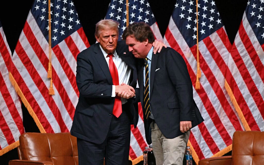 דונלד טראמפ לוחץ את ידו של טאקר קרלסון, 31 באוקטובר 2024 (צילום: Patrick T. Fallon / AFP) דונלד טראמפ לוחץ את ידו של טאקר קרלסון, 31 באוקטובר 2024 (צילום: Patrick T. Fallon / AFP)