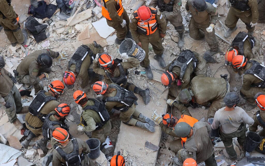 כוחות הצלה ישראליים מחפשים בין ההריסות בזירת מתקפת טילים איראנית לילית בבת ים, 15 ביוני 2025 (צילום: GIL COHEN-MAGEN / AFP) כוחות הצלה ישראליים מחפשים בין ההריסות בזירת מתקפת טילים איראנית לילית בבת ים, 15 ביוני 2025 (צילום: GIL COHEN-MAGEN / AFP)